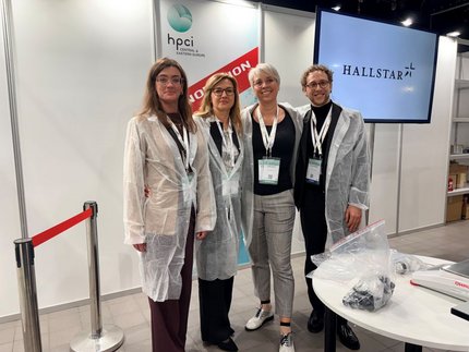 Four people in lab coats at HPCI 2026 in front of a Hallstar screen, ready for the HSH Chemie Innovation Lab session.