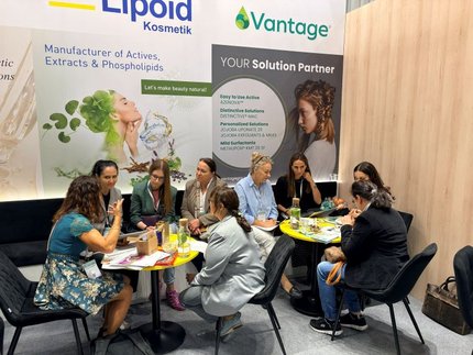 Busy HSH Chemie booth at HPCI 2026, with visitors meeting at tables in front of the Vantage display.
