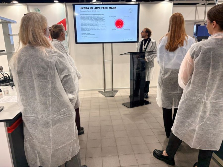 Participants in lab coats watch a presenter introduce the Hydra in Love Face Mask at the HPCI 2026 Innovation Lab.